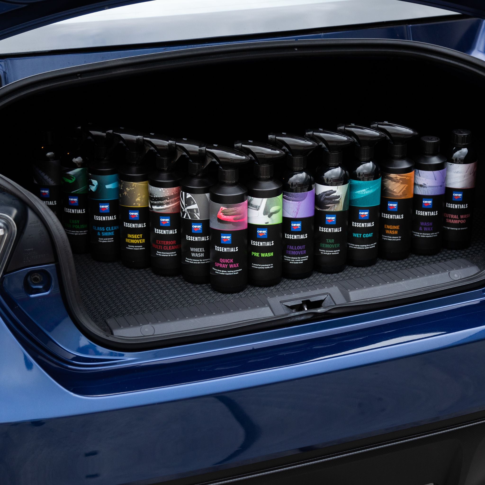 Foto van alle Cartec Essentials flessen op een rijtje in de kofferbak van een auto